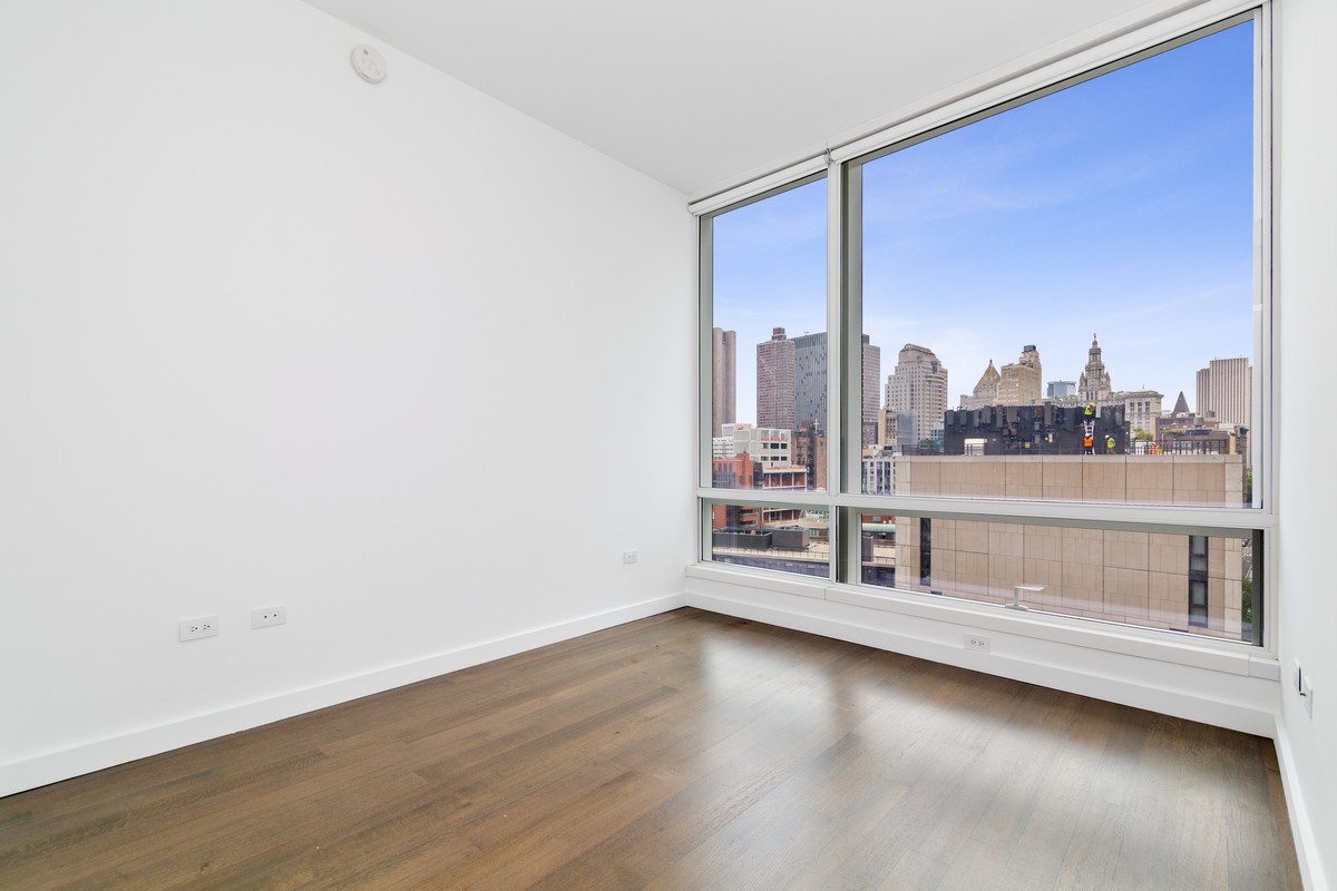 111 Murray Street, Unit 16B Manhattan, NY 10007 - Photo 8 of 22 an empty room with wooden floor and windows