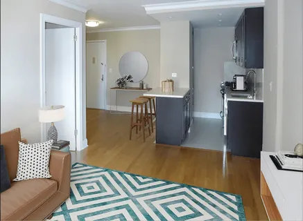 a living room with a couch and a dining table with wooden floor