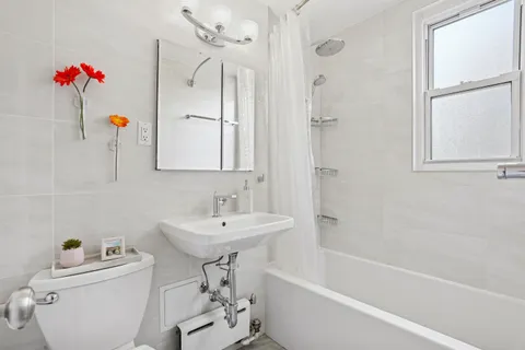 a bathroom with a sink toilet vanity and tub