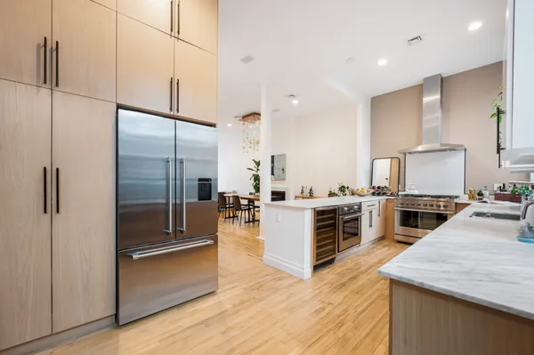 a kitchen with stainless steel appliances kitchen island granite countertop a refrigerator a stove and a sink