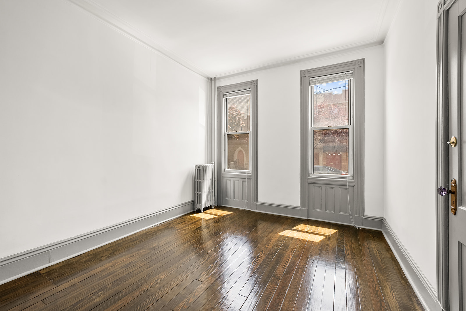 59-45 Palmetto Street Queens, NY 11385 - Photo 9 of 25 an empty room with wooden floor and windows