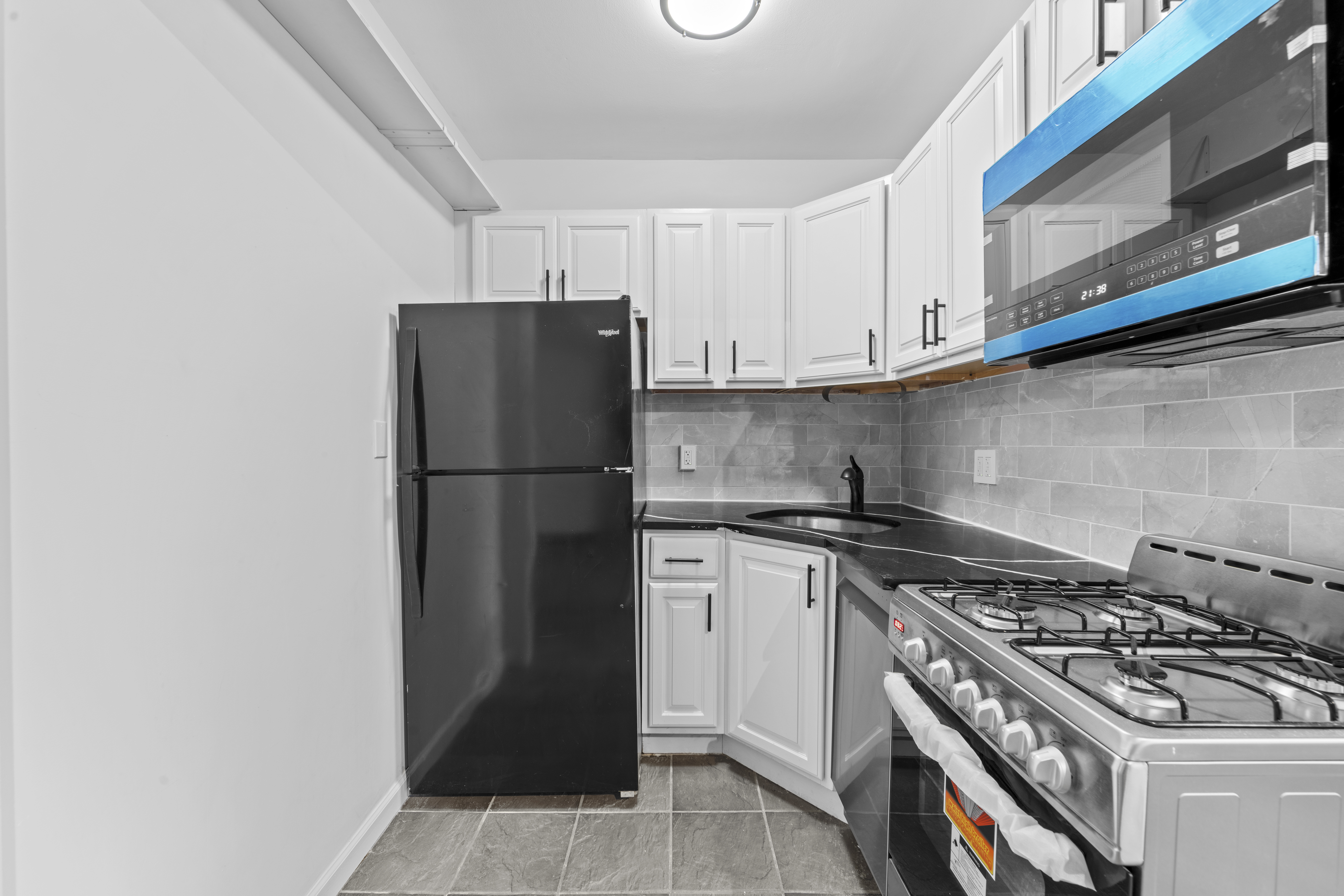 1061 Fulton Street, Unit 3 Brooklyn, NY 11238 - Photo 6 of 14 a kitchen with a stove a refrigerator and a microwave