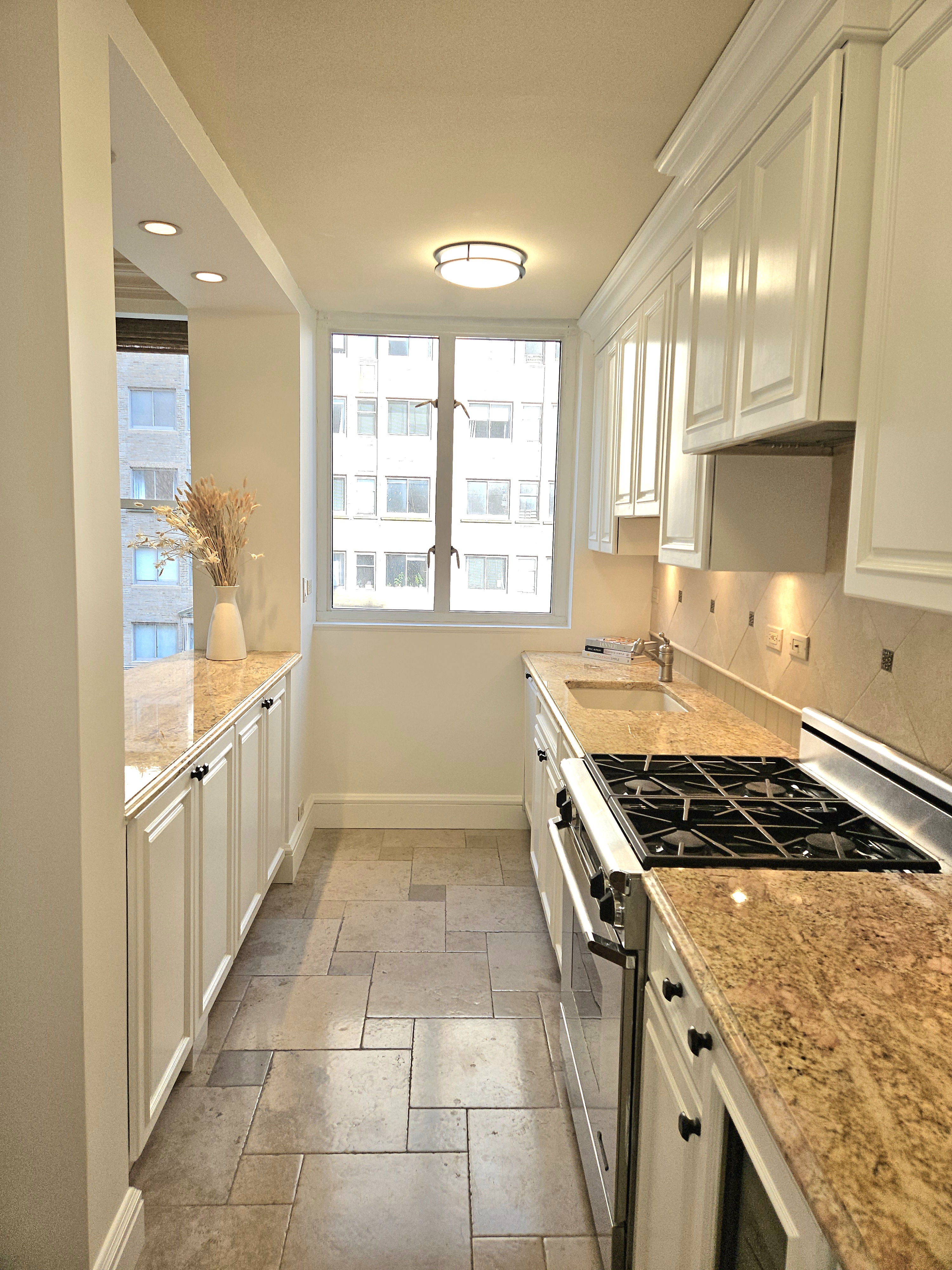 169 East 69th Street, Unit 7/8 B Manhattan, NY 10021 - Photo 10 of 30 a kitchen with a stove a sink and a refrigerator