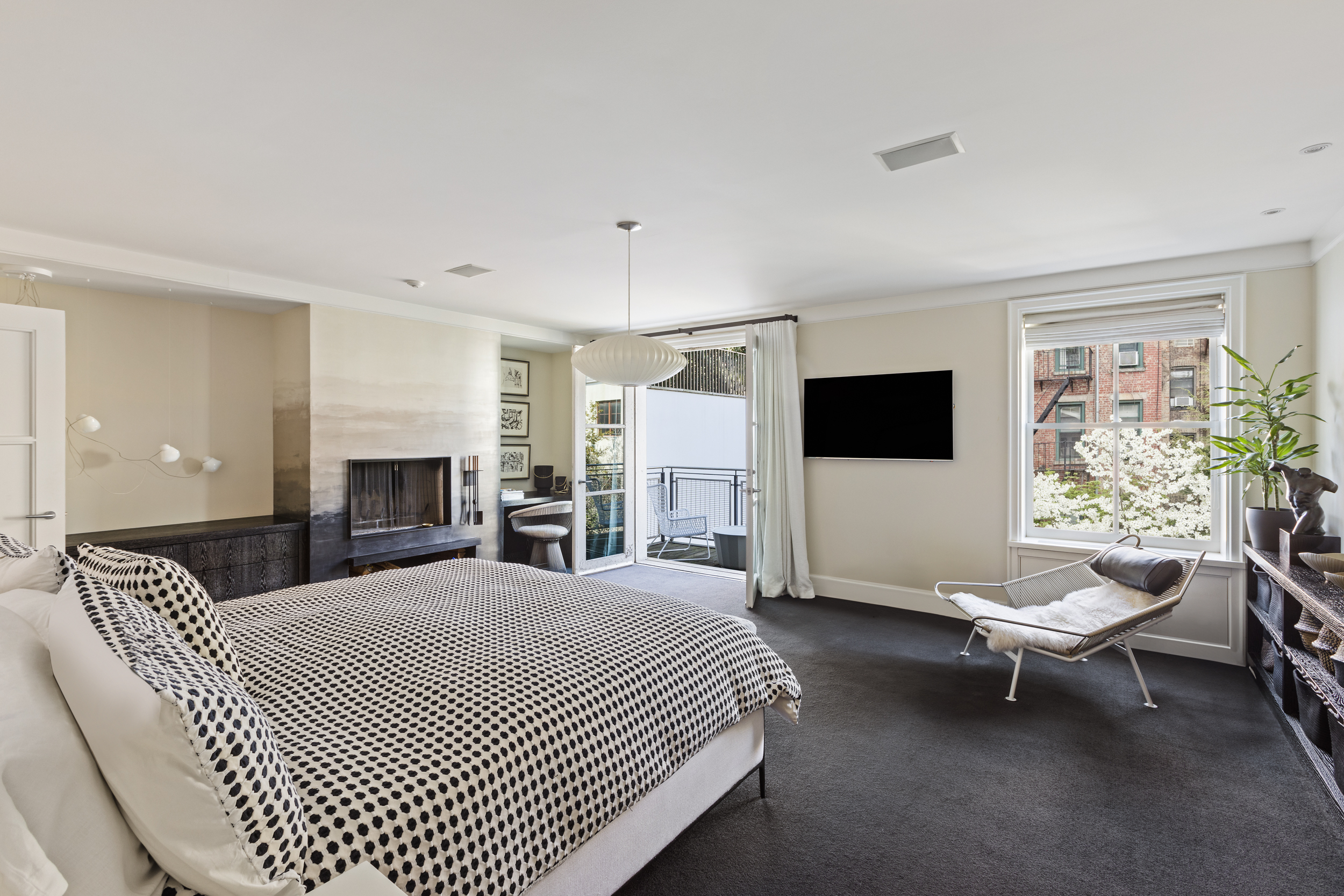 83 Jane Street Manhattan, NY 10014 - Photo 13 of 29 a spacious bedroom with a bed and a flat screen tv