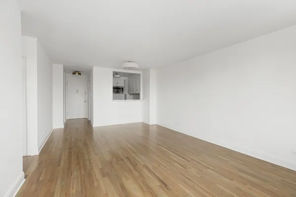 a view of a big room with wooden floor and windows