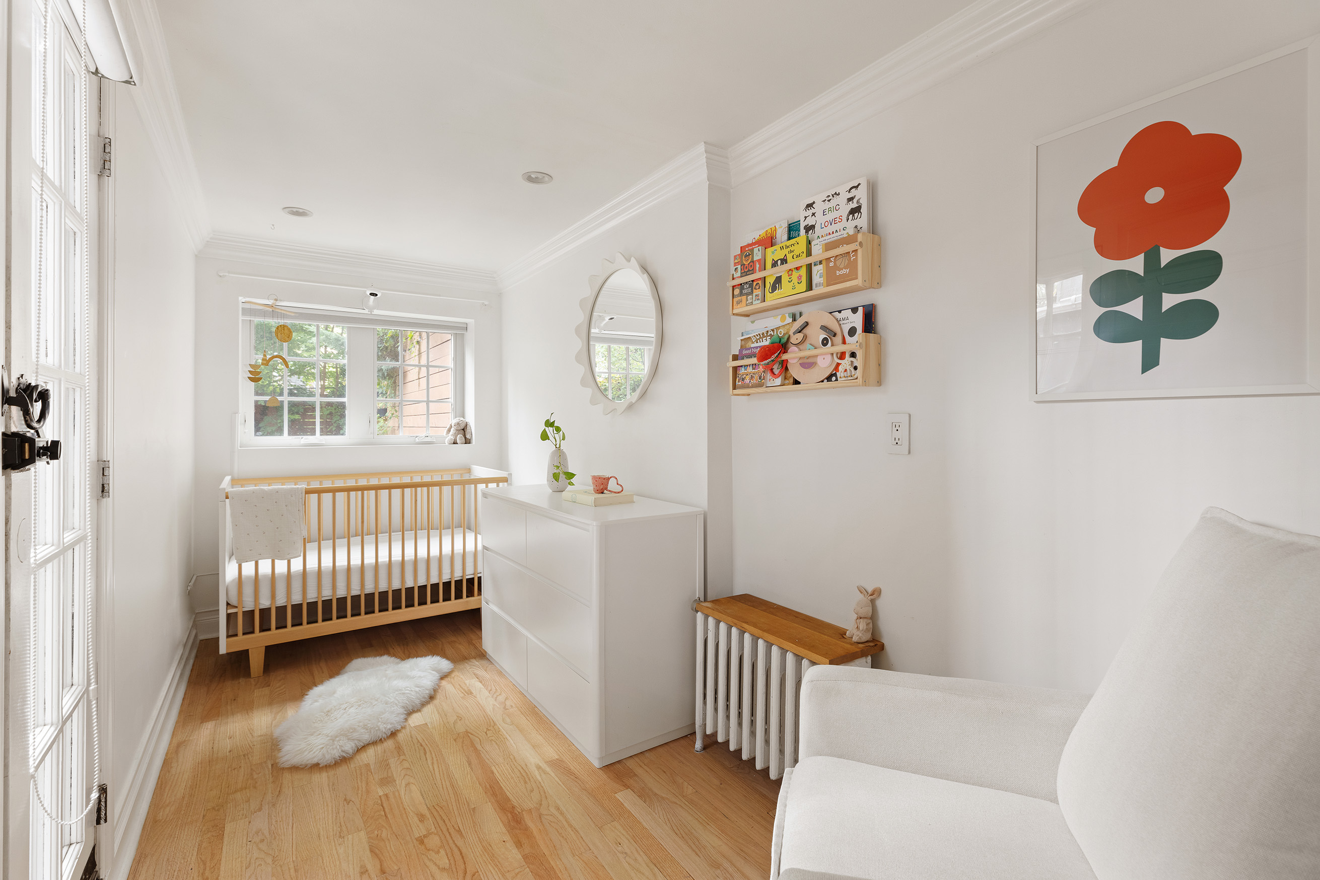 659 Degraw Street, Unit 1 Brooklyn, NY 11217 - Photo 7 of 10 a bedroom with a baby bed a couch and a window with wooden floor