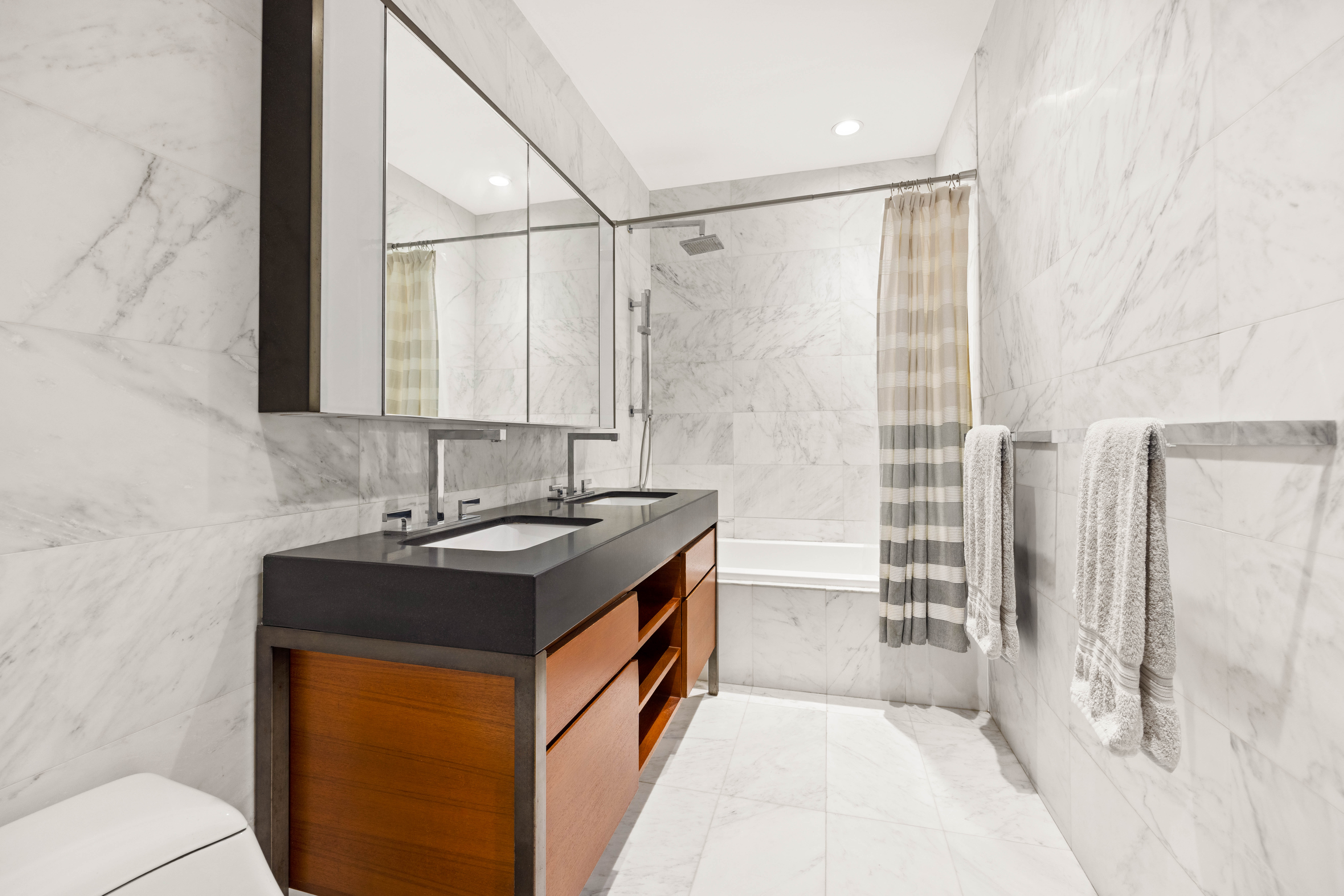 75 Wall Street, Unit 25K Manhattan, NY 10005 - Photo 6 of 9 a bathroom with a sink and a mirror