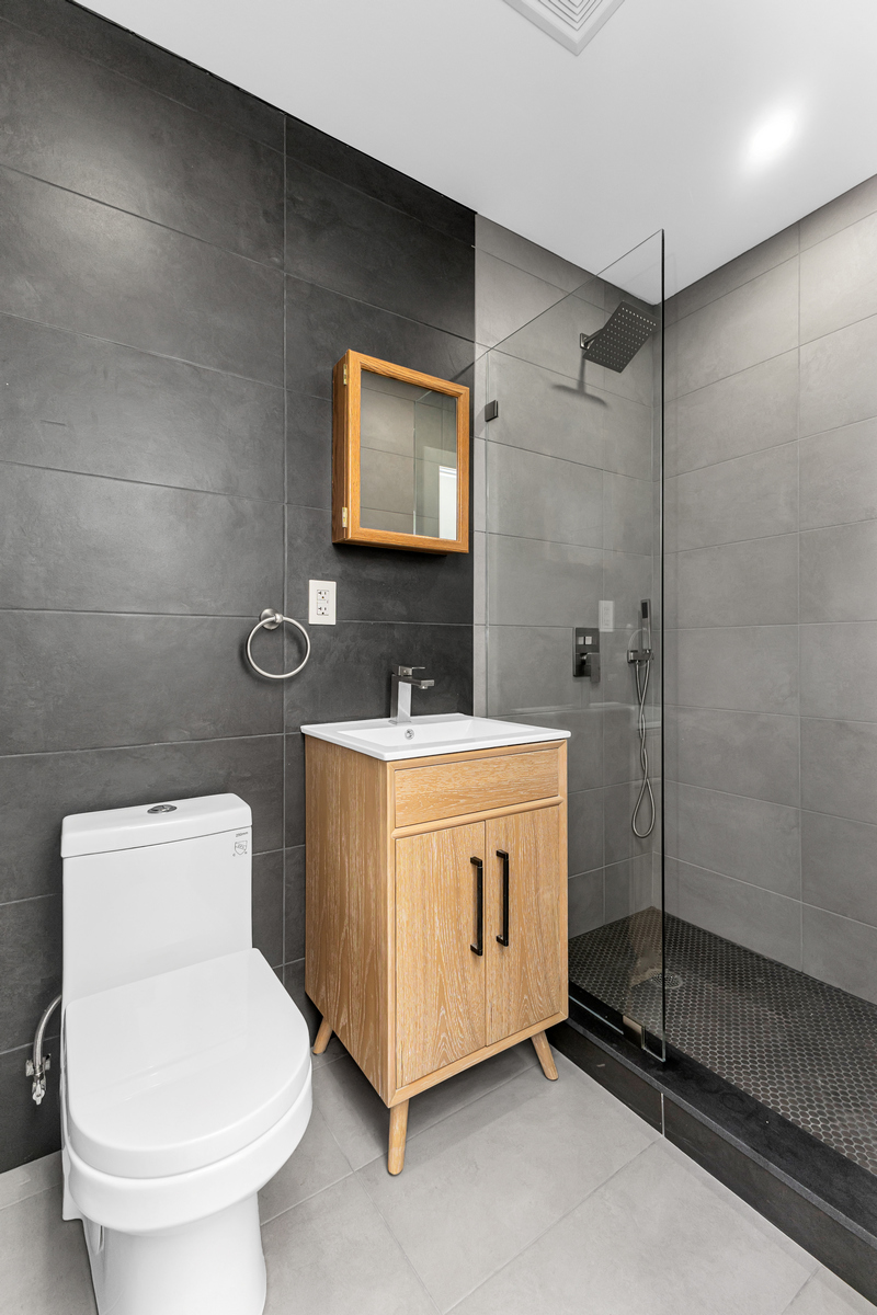 1050 Sterling Place Brooklyn, NY 11213 - Photo 19 of 23 a bathroom with a toilet a sink and mirror