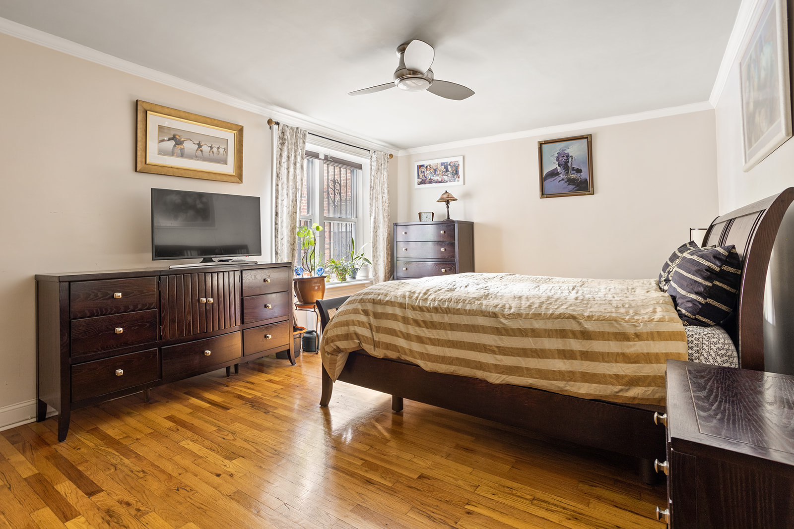 79-10 34th Avenue, Unit 2G Queens, NY 11372 - Photo 6 of 11 a bedroom with a bed and a flat screen tv