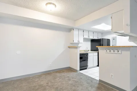 a kitchen with a refrigerator a stove top oven and cabinets