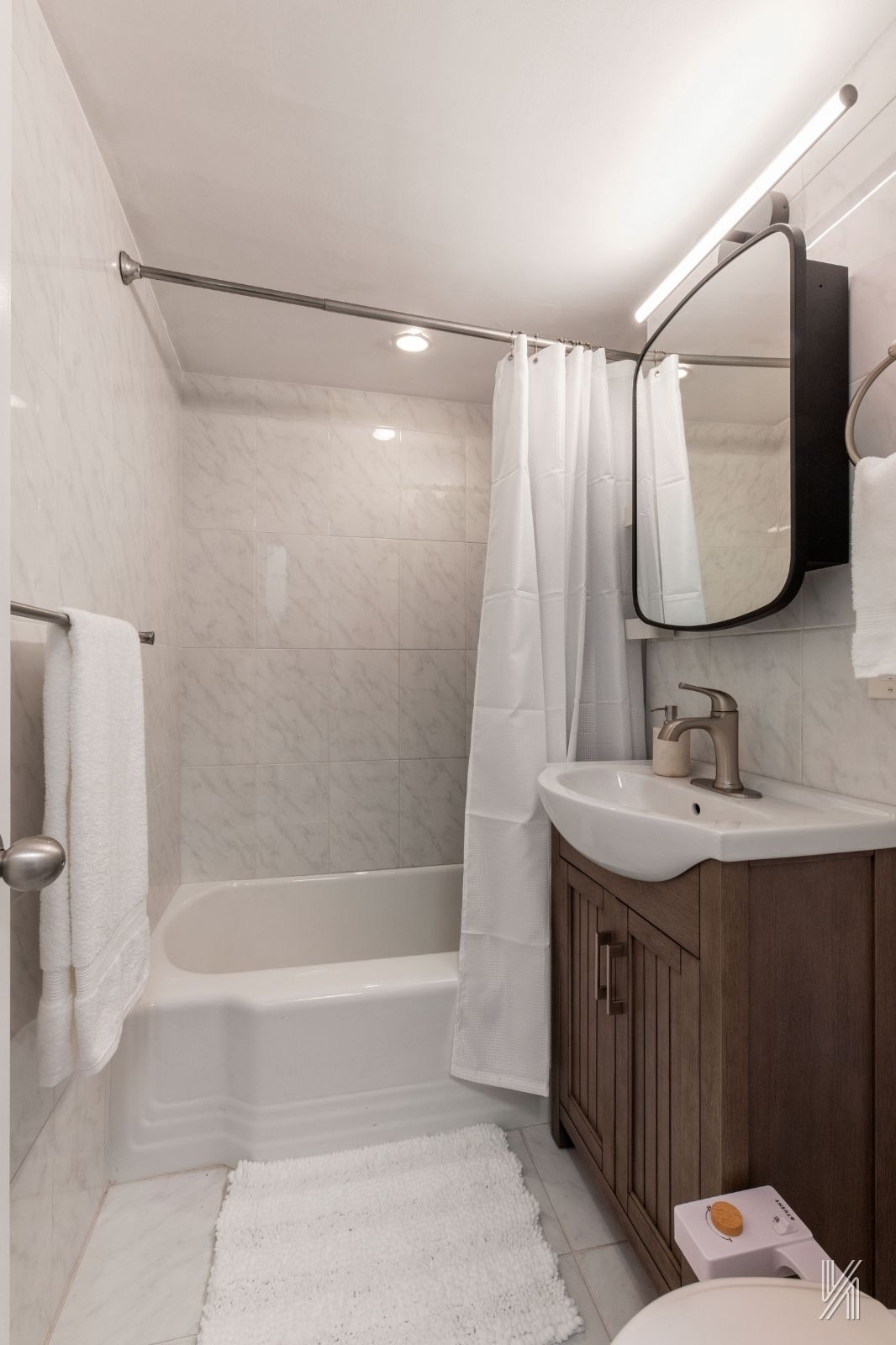 35-50 85th Street, Unit 7H Queens, NY 11372 - Photo 13 of 16 a bathroom with a sink and a mirror
