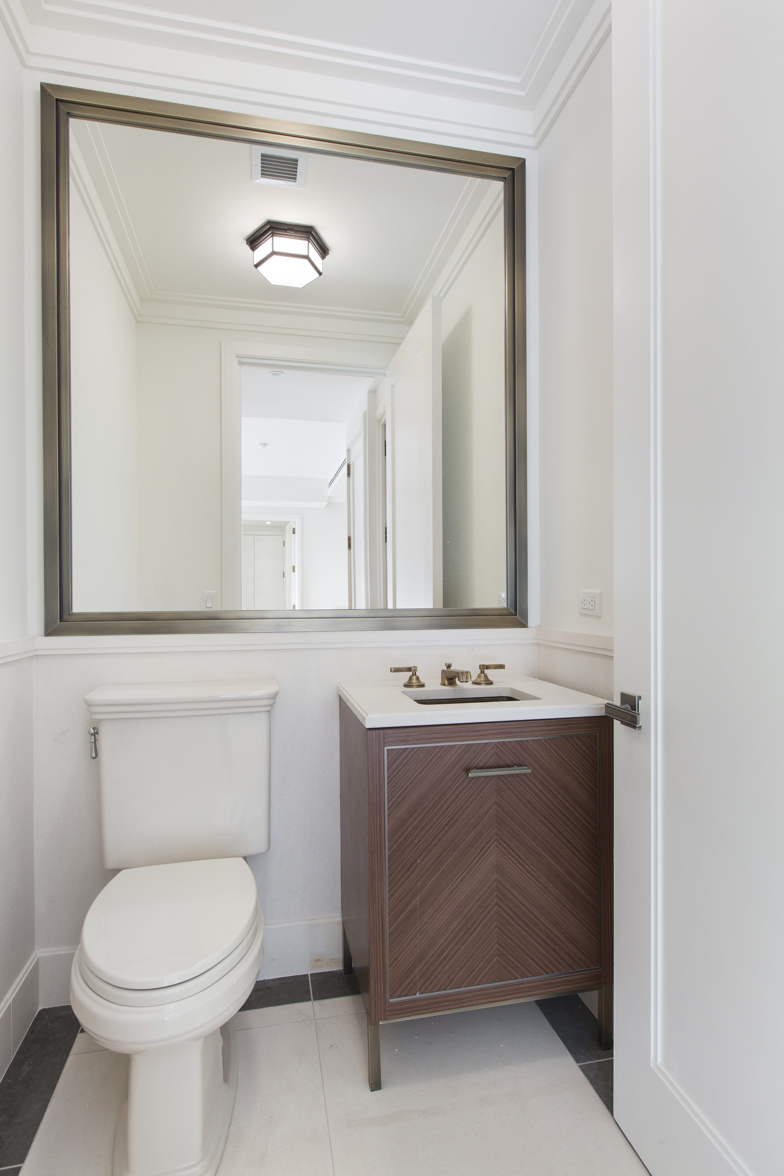 100 Barclay Street, Unit 14K Manhattan, NY 10007 - Photo 3 of 9 a bathroom with a sink a toilet and mirror