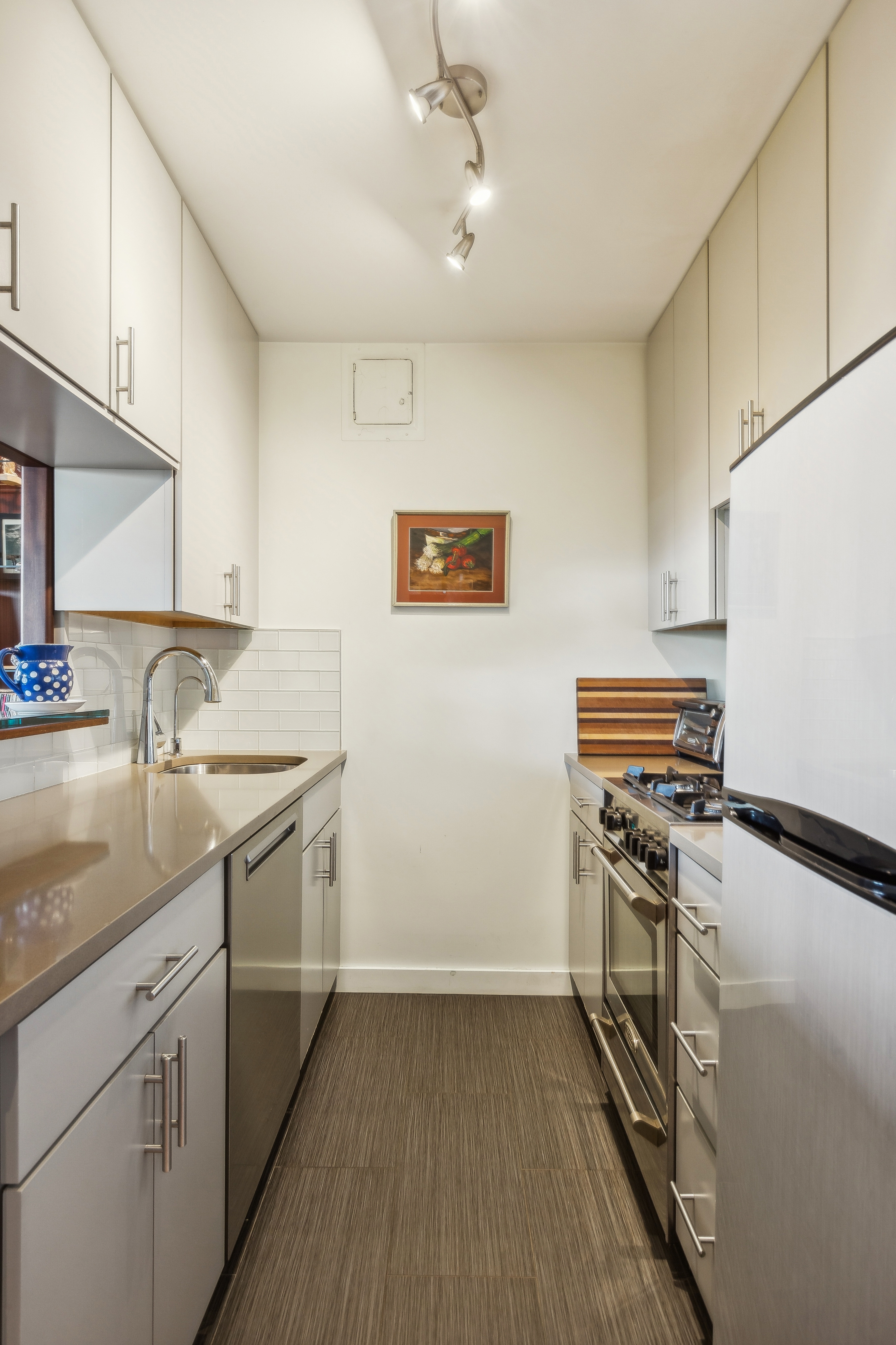 210 East 15th Street, Unit PHD Manhattan, NY 10003 - Photo 6 of 12 a kitchen with granite countertop a sink stove and cabinets