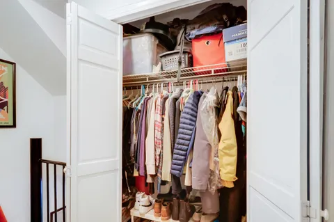 a view of walk in closet with clothes and shoes