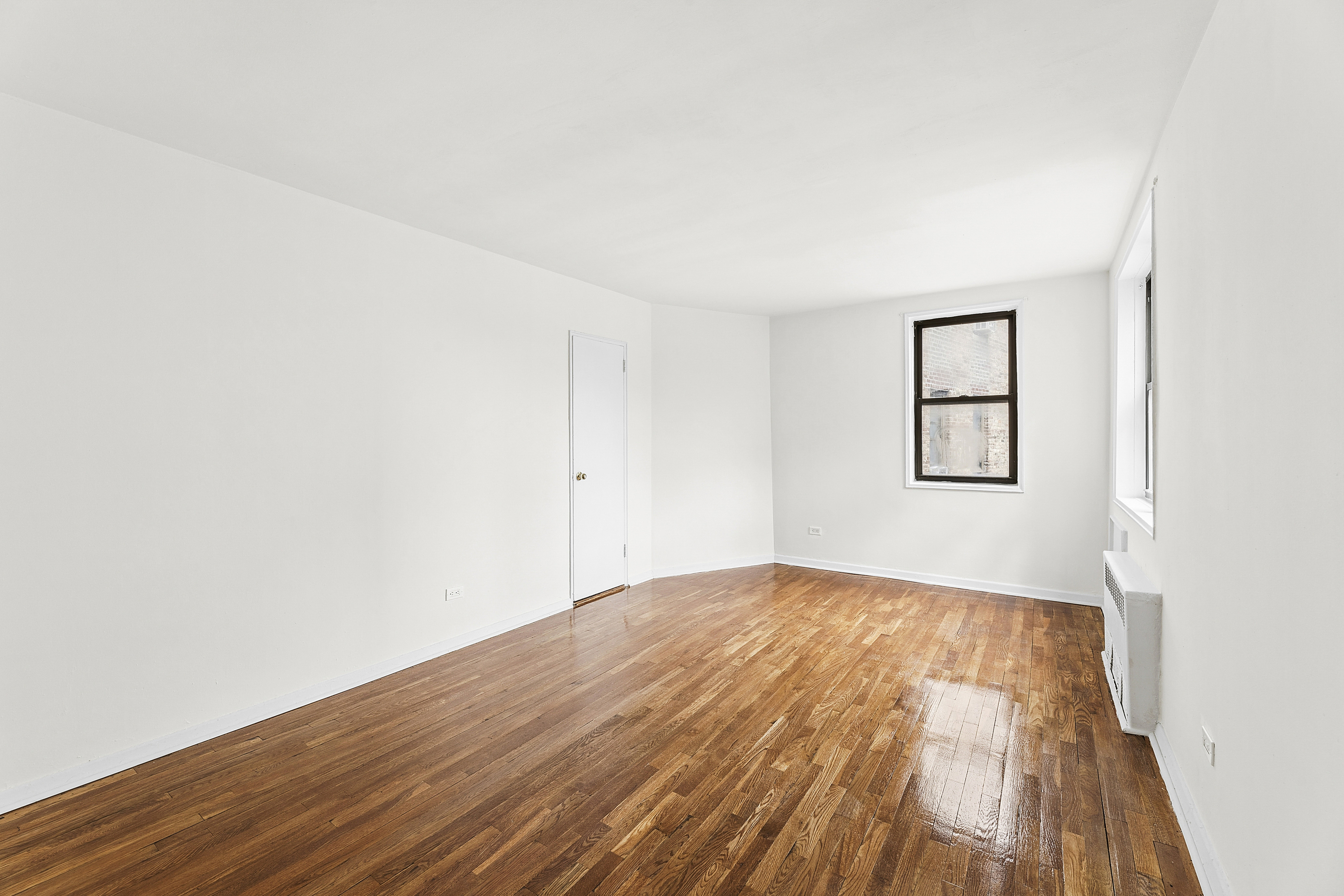 6645 Broadway, Unit 7E Bronx, NY 10471 - Photo 9 of 11 an empty room with wooden floor and windows