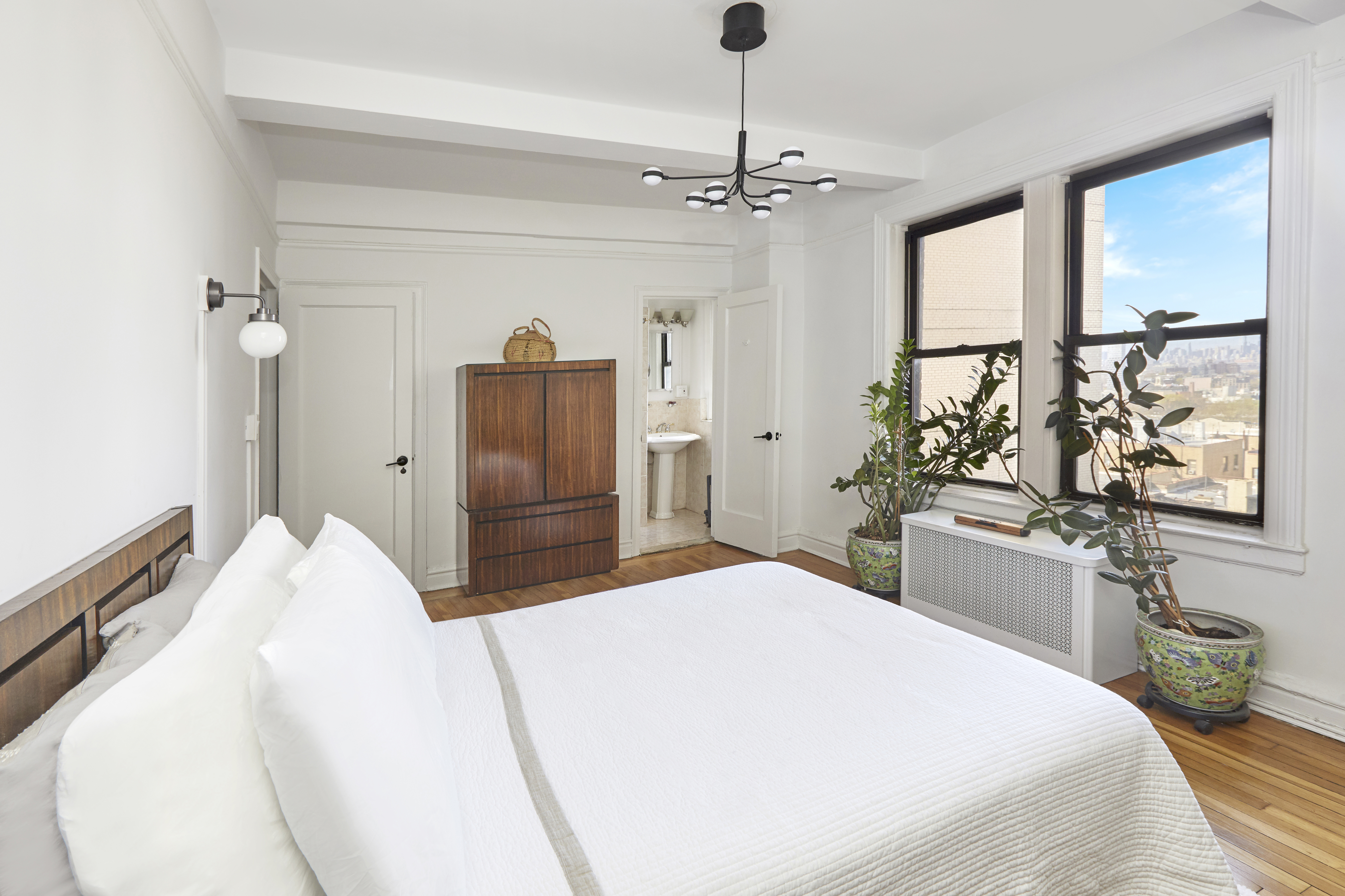 135 Eastern Parkway, Unit 9I Brooklyn, NY 11238 - Photo 10 of 17 a bedroom with a large bed and a chandelier