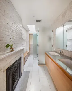 a spacious bathroom with a granite countertop double vanity sink a mirror and a bathtub