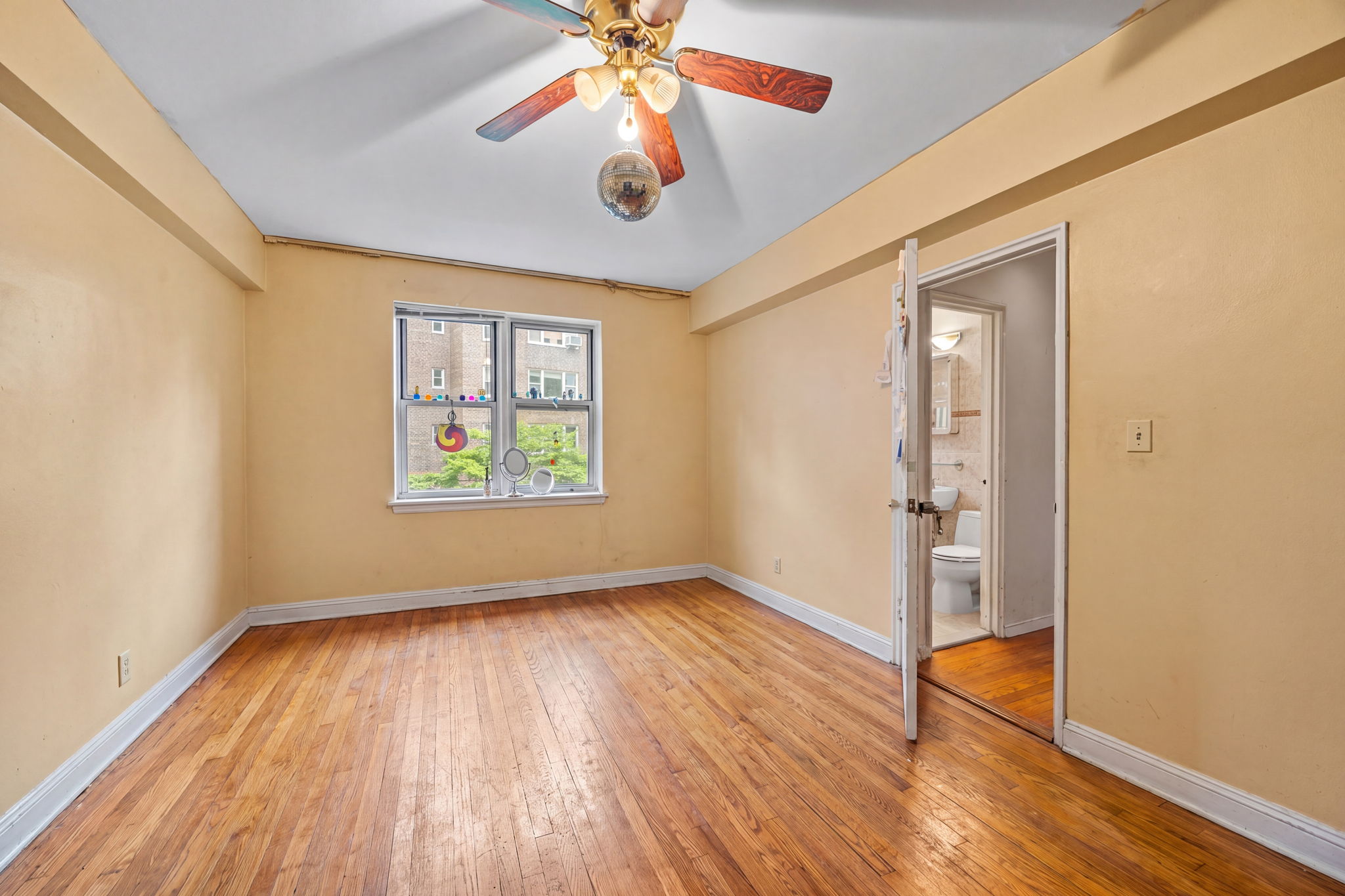 3850 Hudson Manor Terrace, Unit 1EE/2EE Bronx, NY 10463 - Photo 7 of 27 an empty room with wooden floor chandelier fan and windows