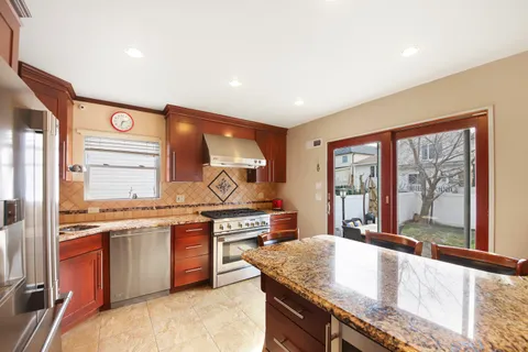 a kitchen with stainless steel appliances granite countertop sink stove and refrigerator