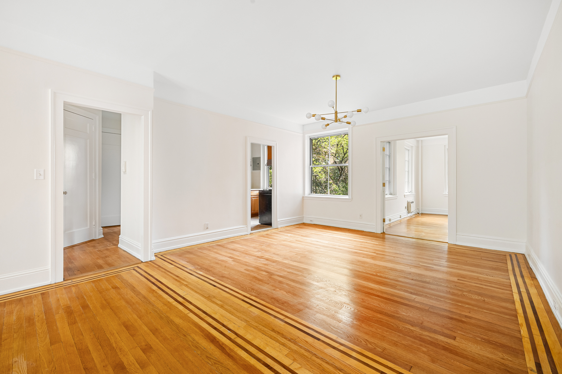 35-27 76th Street, Unit 21 Queens, NY 11372 - Photo 6 of 24 a view of an empty room with window and wooden floor