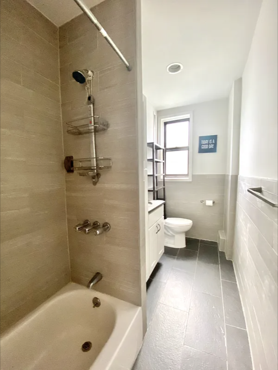 567 6th Street, Unit 10 Brooklyn, NY 11215 - Photo 4 of 14 a bathroom with a white tub shower and toilet