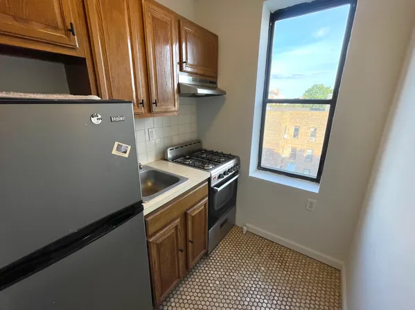 a kitchen with granite countertop a sink a stove and refrigerator