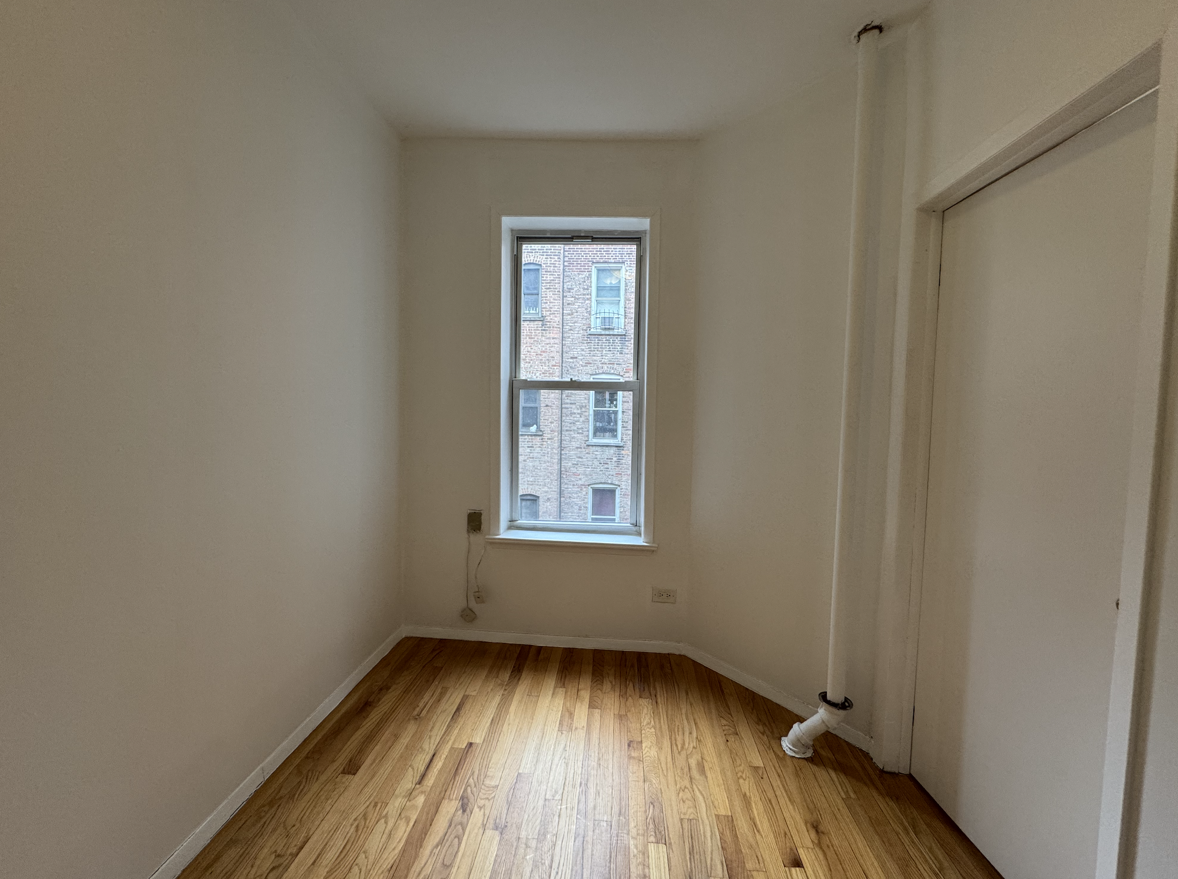 451 West 44th Street, Unit 63 Manhattan, NY 10036 - Photo 13 of 31 a view of an empty room with wooden floor and a window