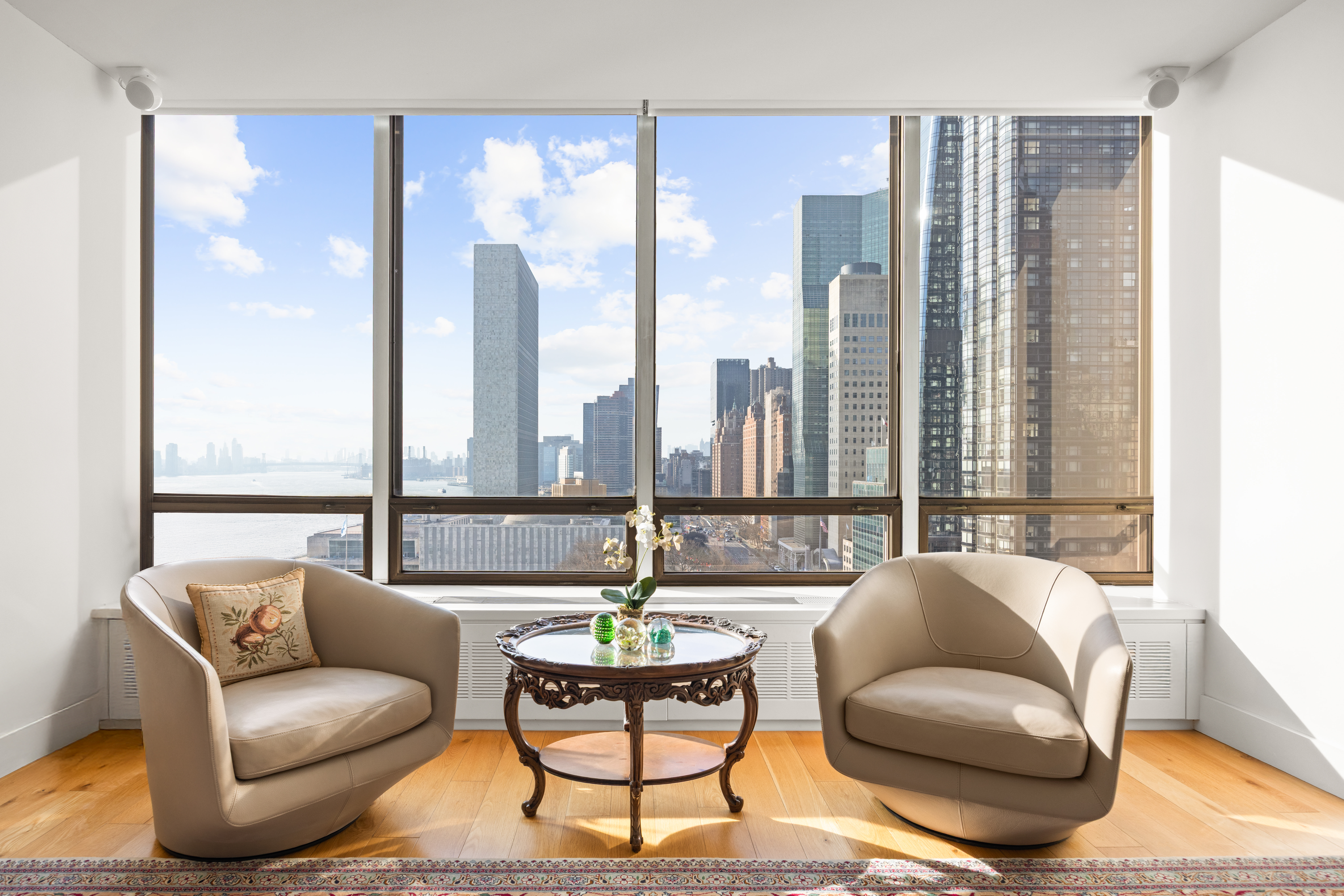 860 United Nations Plaza, Unit 16G Manhattan, NY 10017 - Photo 4 of 12 a living room with furniture and a large window