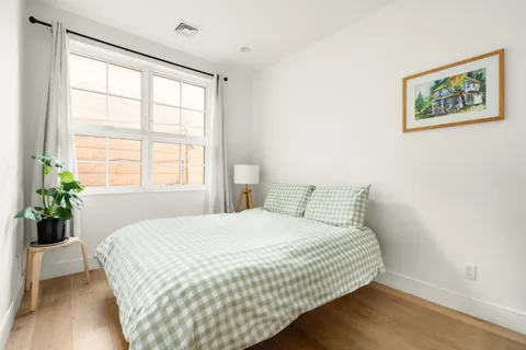 a bedroom with a bed and a large window