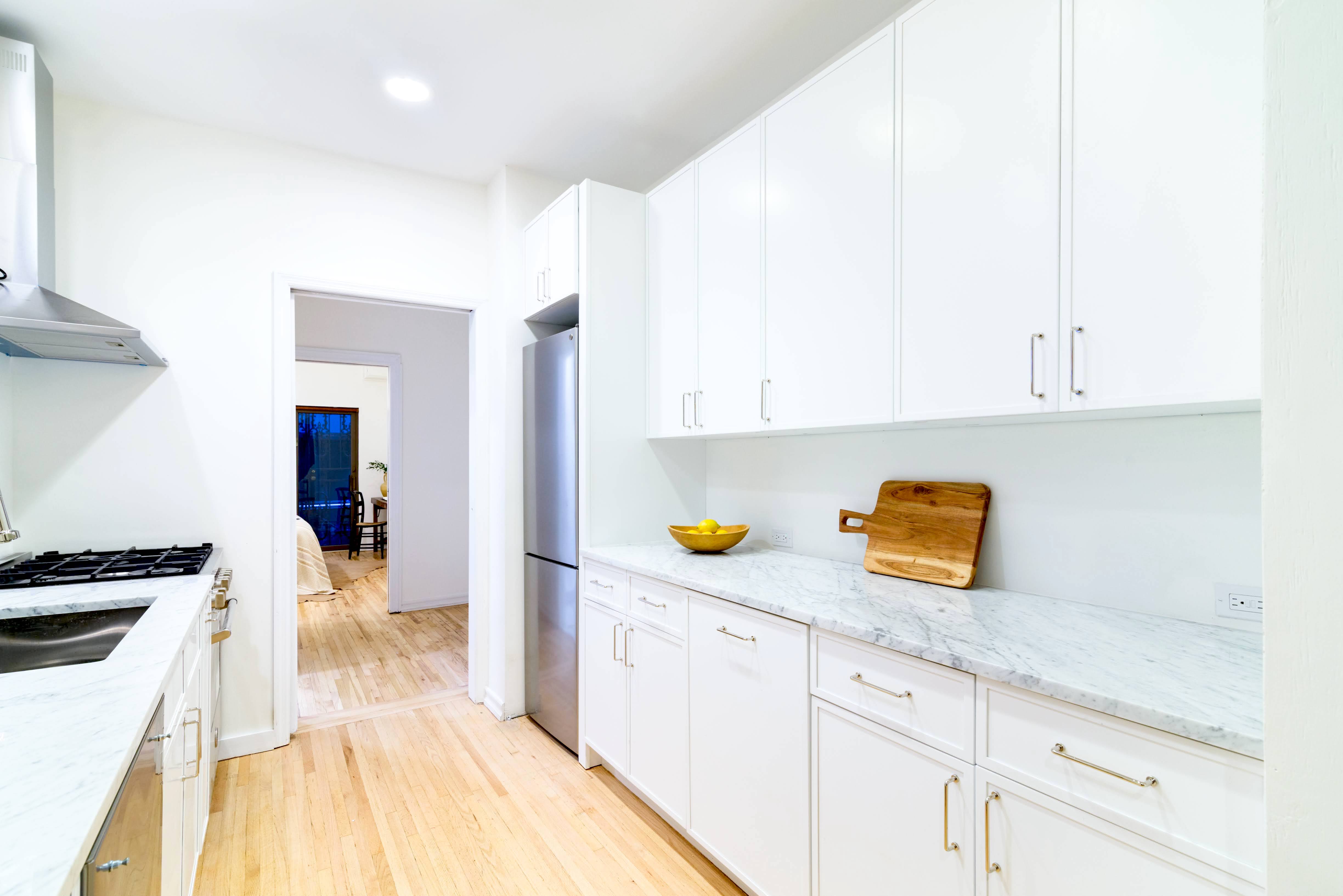 349 West 71st Street Manhattan, NY 10023 - Photo 7 of 21 a kitchen with a sink a stove and cabinets