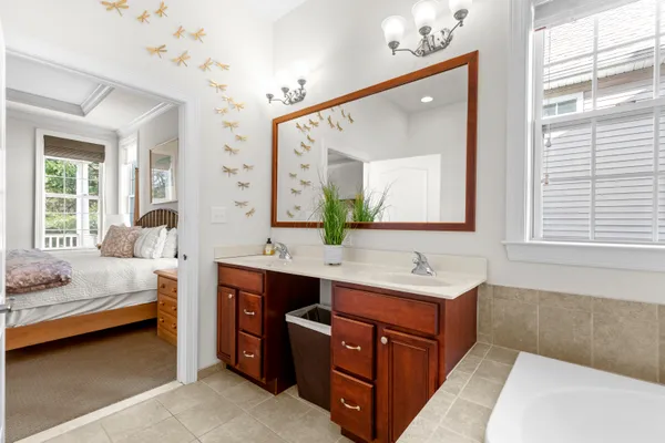 a bathroom with a sink vanity tub and a mirror