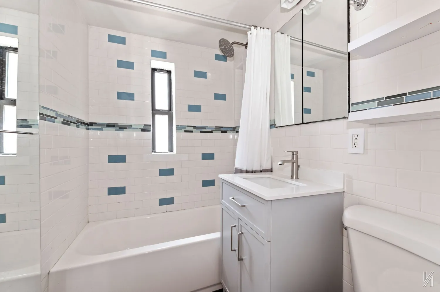 a bathroom with a granite countertop sink a toilet a mirror a bathtub and shower