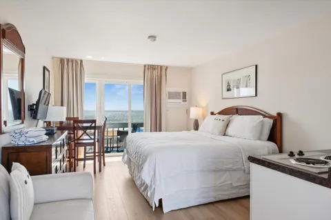 a bedroom with a bed and a flat tv screen on wall