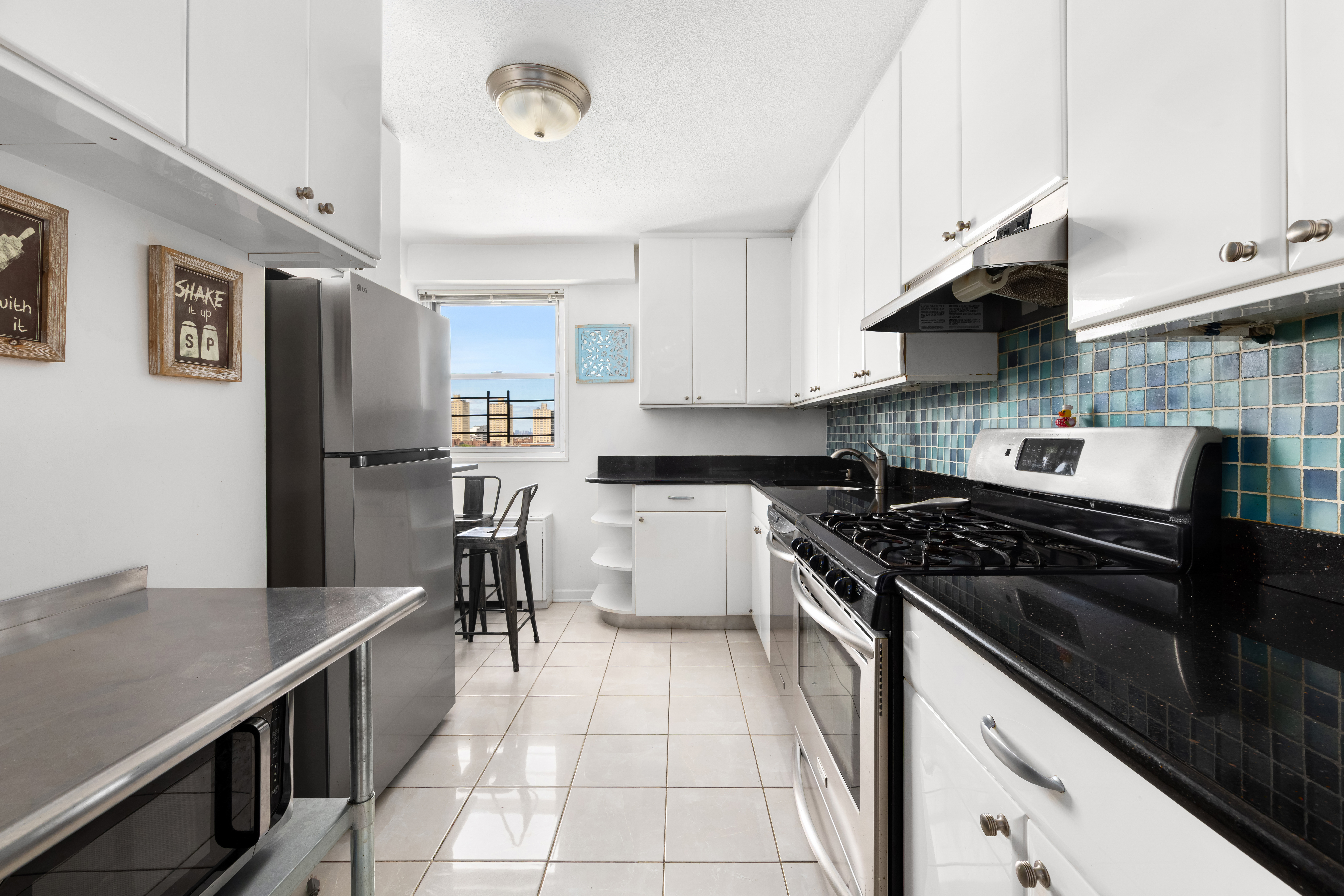 70-31 108th Street, Unit 12D Queens, NY 11375 - Photo 4 of 16 a kitchen with stainless steel appliances granite countertop a stove refrigerator and cabinets