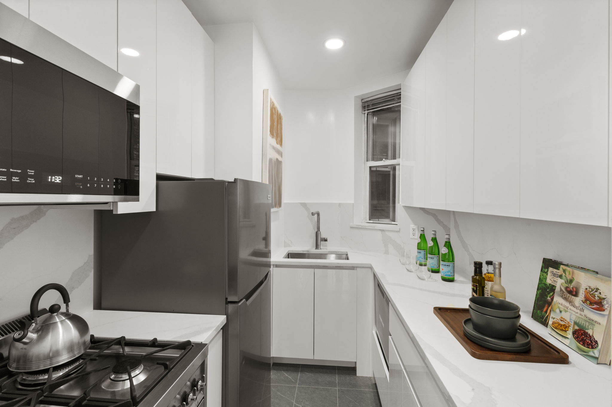 237 East 12th Street, Unit 2A Manhattan, NY 10003 - Photo 7 of 16 a kitchen with stainless steel appliances a sink stove and refrigerator