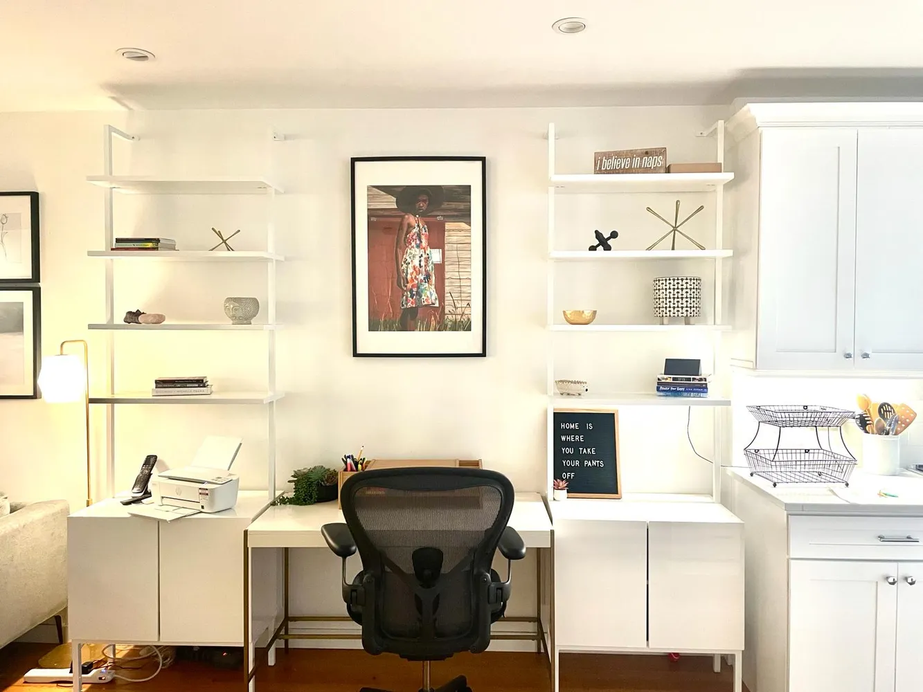a view of a workspace with furniture and a window