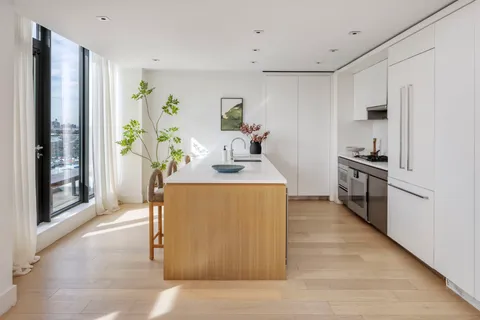 a kitchen with kitchen island a counter top space a sink stainless steel appliances and cabinets