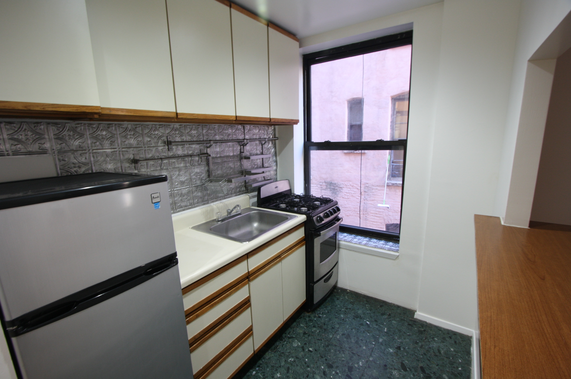 435 East 75th Street, Unit 13 Manhattan, NY 10021 - Photo 2 of 6 a kitchen with a stove and a microwave