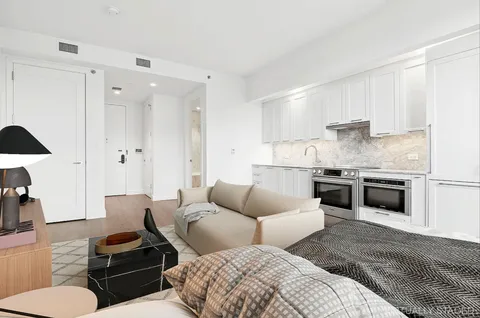 a living room with furniture and kitchen view