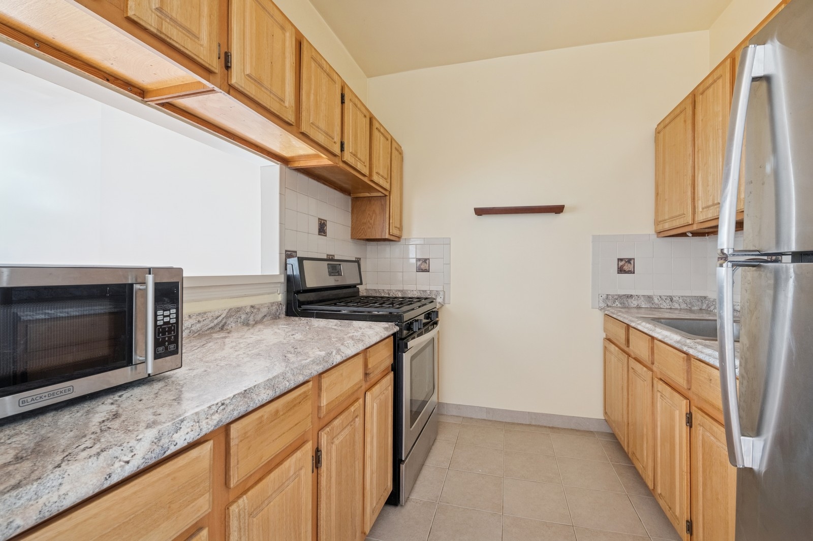 859 Riverside Drive, Unit 3 Manhattan, NY 10032 - Photo 2 of 7 a kitchen with stainless steel appliances granite countertop a stove and a refrigerator
