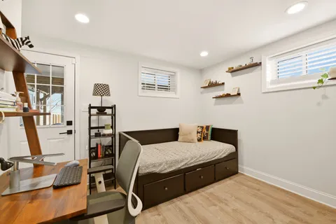 a bedroom with a bed and large windows