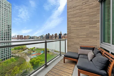a view of a balcony with wooden chairs and floor to ceiling window