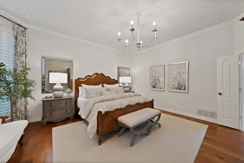 a spacious bedroom with a bed and a chandelier