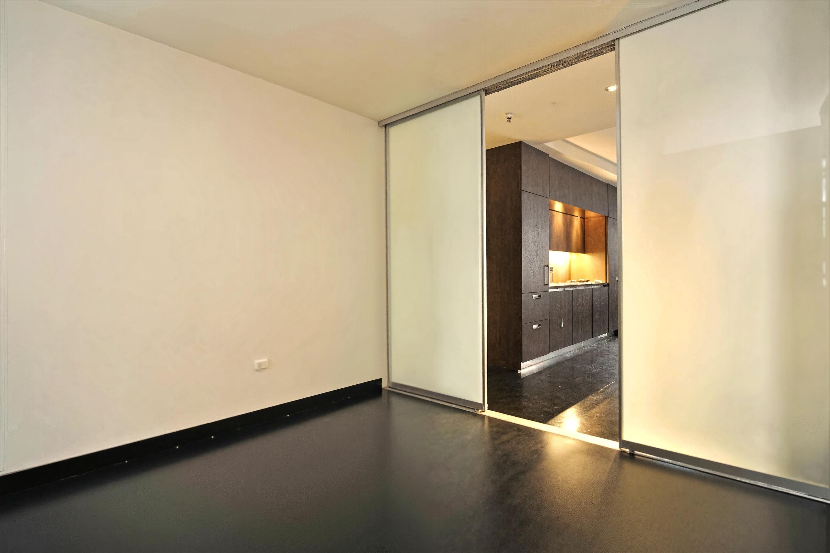 20 Pine Street, Unit 805 Manhattan, NY 10005 - Photo 2 of 8 an empty room with wooden floor and door