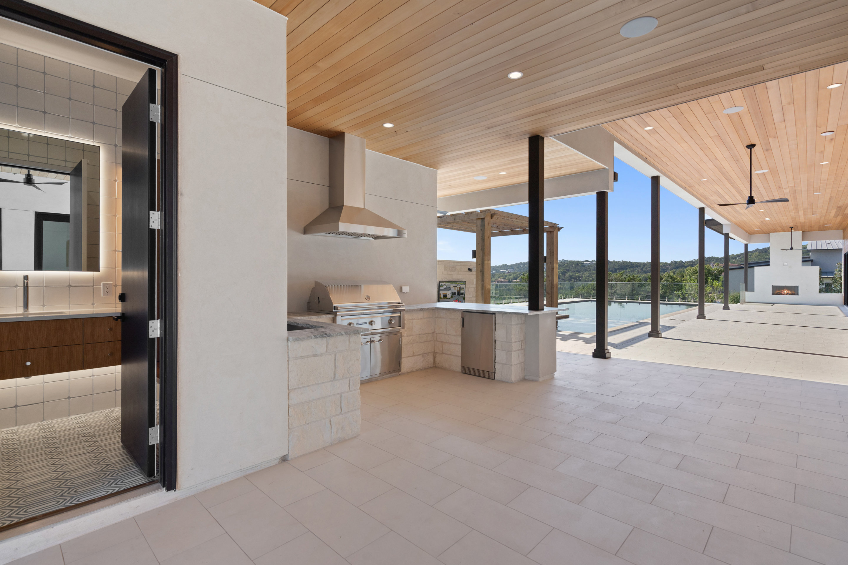 1905 Hallam Drive Austin, TX 78746 - Photo 39 of 39 a view of open kitchen with stainless steel appliances wooden cabinets and a fireplace