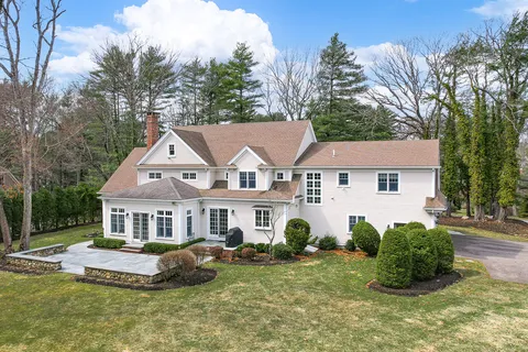 a front view of a house with a garden and trees