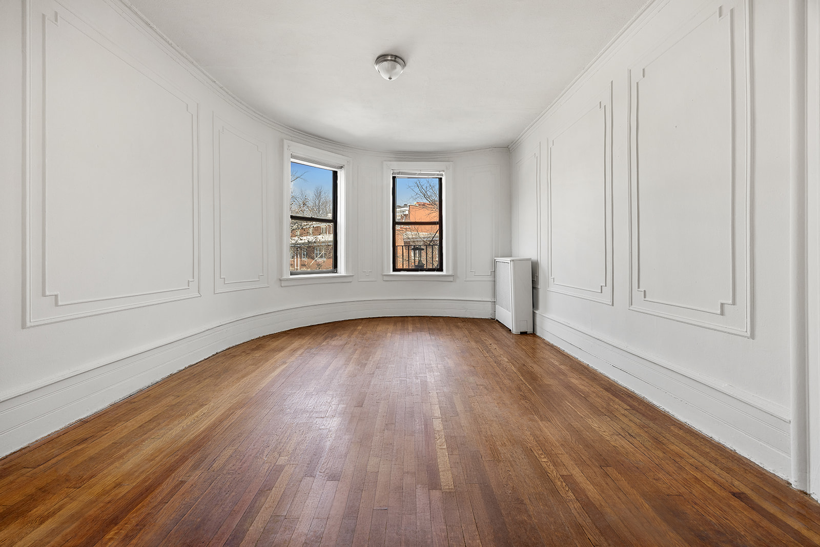 310 Windsor Place, Unit 32 Brooklyn, NY 11218 - Photo 2 of 19 an empty room with wooden floor and windows