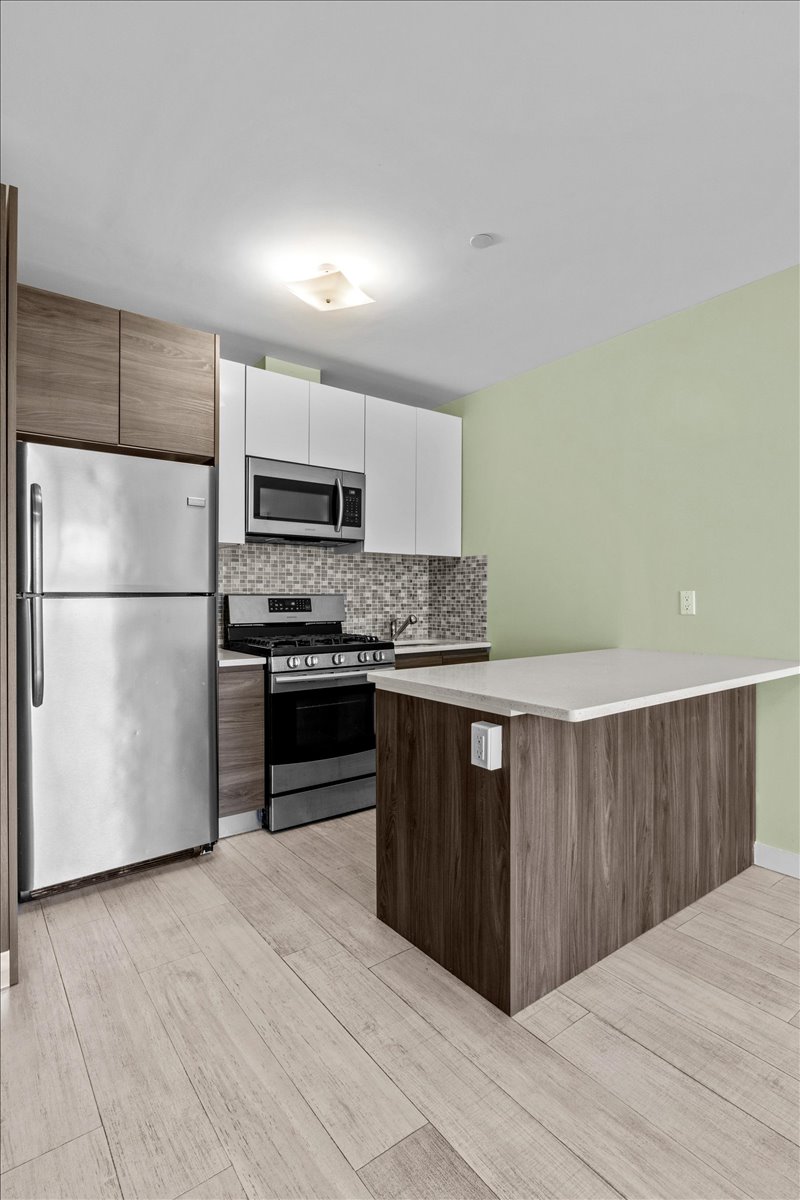 1972 Ocean Avenue, Unit 4A Brooklyn, NY 11230 - Photo 7 of 18 a kitchen with granite countertop a refrigerator and a stove top oven