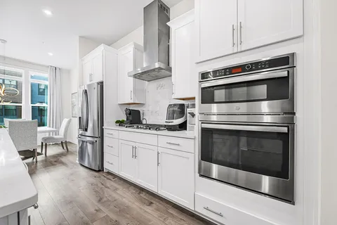 a kitchen with stainless steel appliances a stove a refrigerator and cabinets