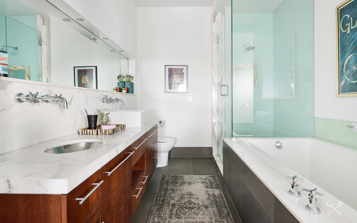 60 Broadway, Unit 10M Brooklyn, NY 11249 - Photo 8 of 12 a bathroom with a tub sink and mirror